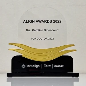 um troféu de vidro com traços dourados perto da base preta com o símbolo da invisalign