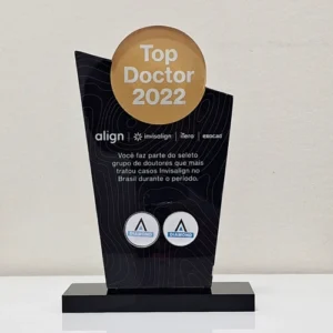 um troféu conquistado pela dra caroline como top doctor 2022 na cor preta com um disco dourado ao topo